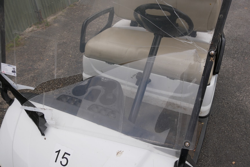 A golf buggy with a smashed windscreen.