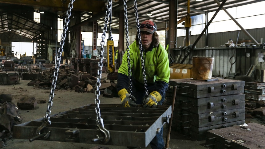 Justin at work in the foundry guiding a load.