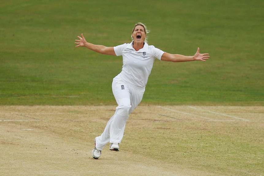 England fast bowler Katherine Brunt has her arms outstretched and she is running to celebrate a wicket.