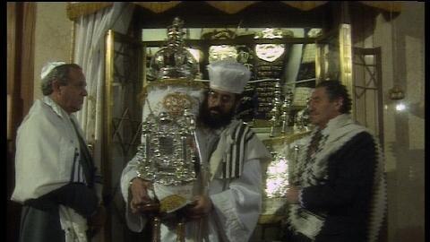 Rabbi carries silver ornament in synagogue