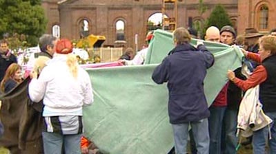 Colleagues hold blankets around the body of Richard Carleton.