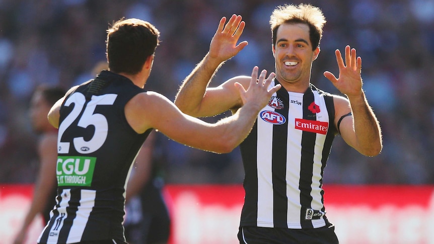 Jack Crisp celebrates a goal with Steele Sidebottom (R) of Collingwood against Essendon at the MCG.