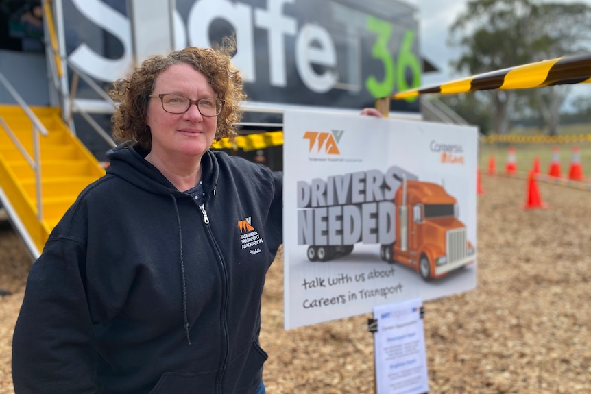 Tasmanian Transport Association executive director Michelle Harwood stands in front of a sign saying 'drivers wanted'