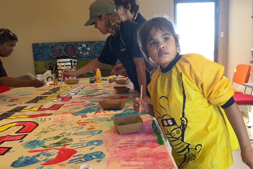 you girl and boys painting a sign