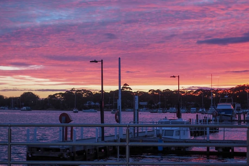 Boats in the harbour as the sun sets over Raymond Island.