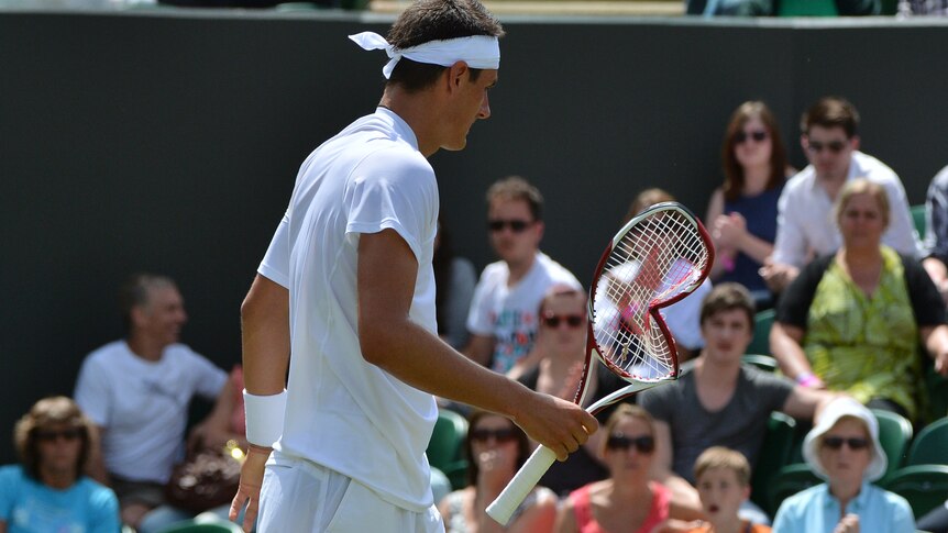 Bernard Tomic with his damaged racquet
