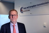 Alan Macsporran stands in front of a Crime and Corruption Commission sign
