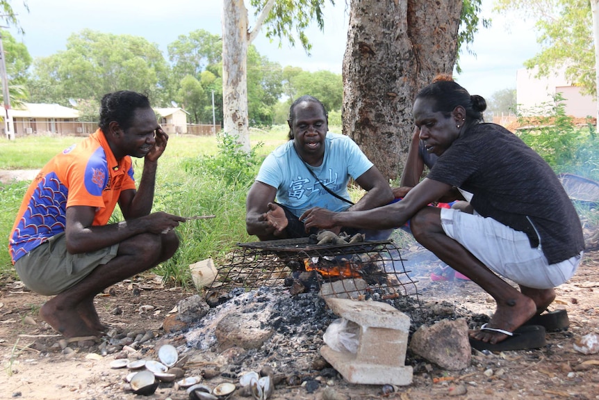 Buffy Warlapinni, Nicole Miller and Ainsley Kerinaiua cook clams and longbums.