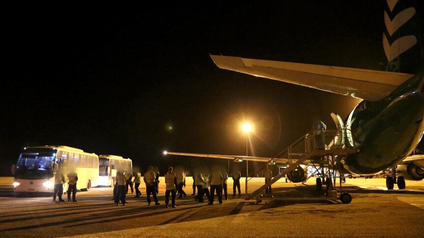 The first group of 40 asylum seekers board a plane on Christmas Island bound for Manus Island.