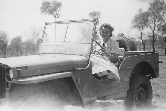 A woman driving a car on an outback station