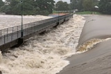 Floodwaters rush over the Aplins Weir in Townsville