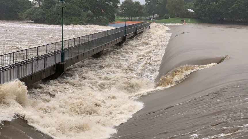 Floodwaters rush over the Aplins Weir in Townsville
