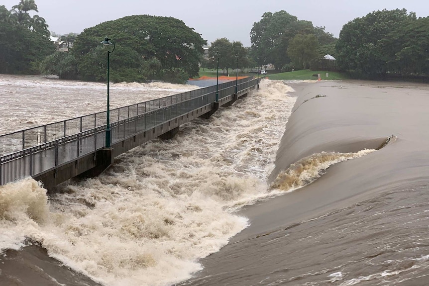 Floodwaters rush over the Aplins Weir in Townsville