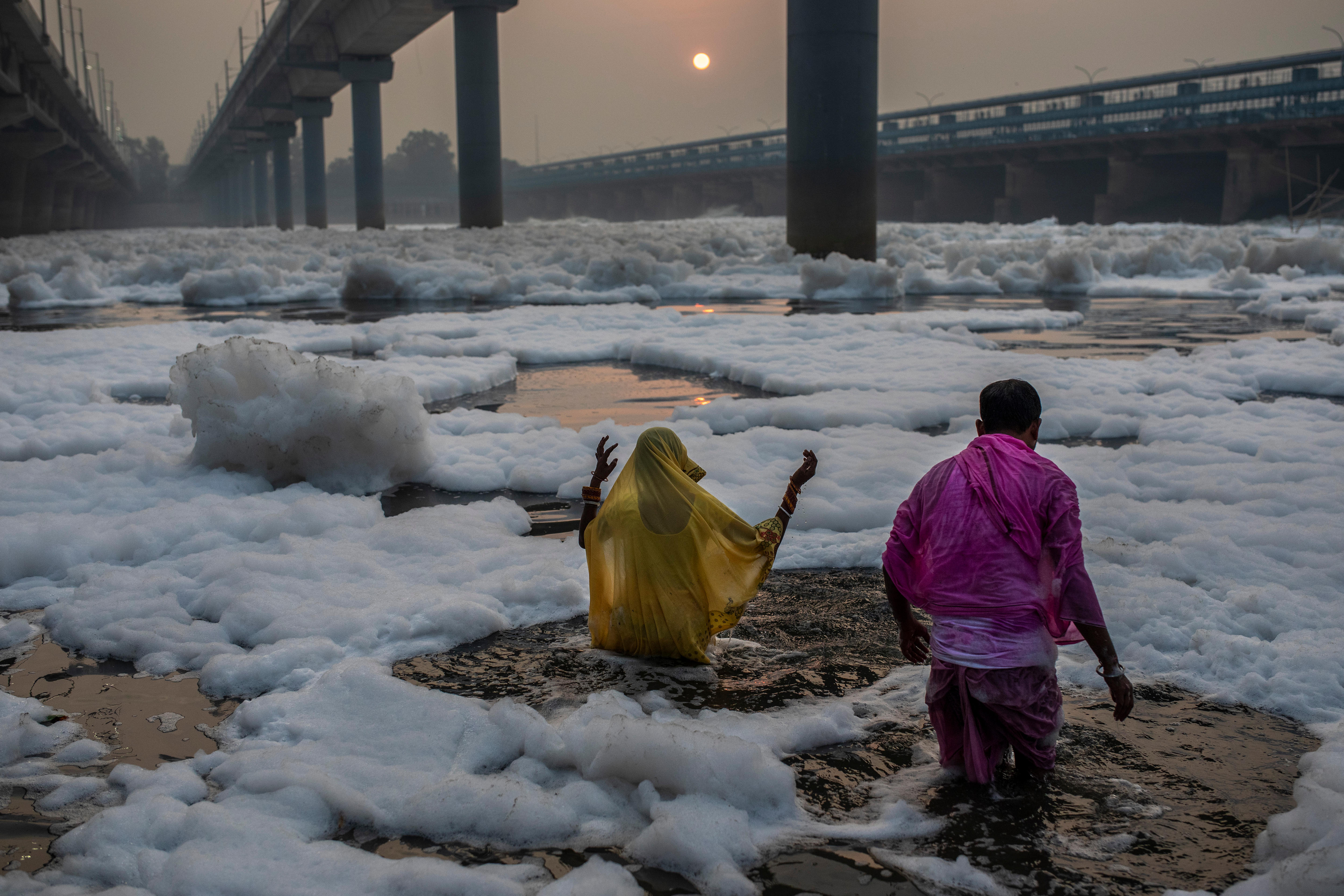 Hindu devotees perform rituals in the river