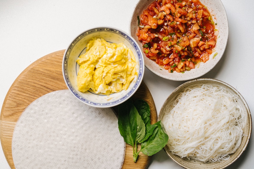 Cooked eggs, tomato, basil, vermicelli and rice paper are all ingredients in a summer rice paper roll recipe.