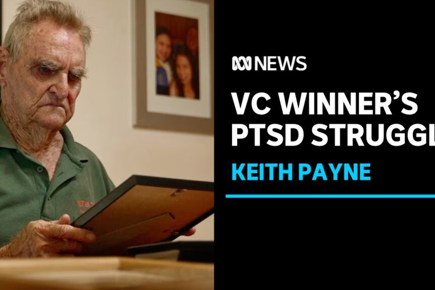 VC Winner's PTSD Struggle, Keith Payne: A man examines a framed photograph.
