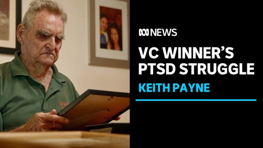 VC Winner's PTSD Struggle, Keith Payne: A man examines a framed photograph.
