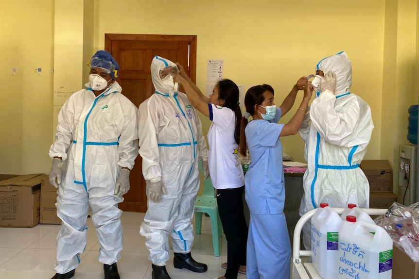 Doctors in Cambodia apply PPE before treating COVID-19 patients.