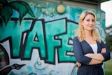 Nada Hassoun stands in front of a graffitied wall at the Tropical North Queensland TAFE campus in Cairns.