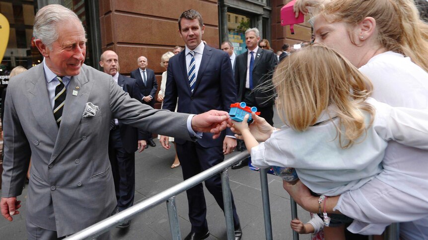 Prince Charles is offered a Thomas the Tank Engine toy by a toddler during a walk-through of Martin Place.