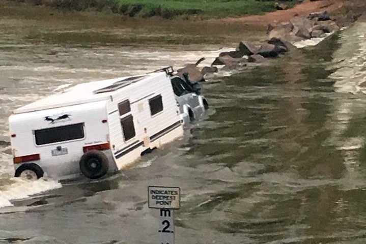 Car and caravan get stuck at Cahill's Crossing in Kakadu National Park