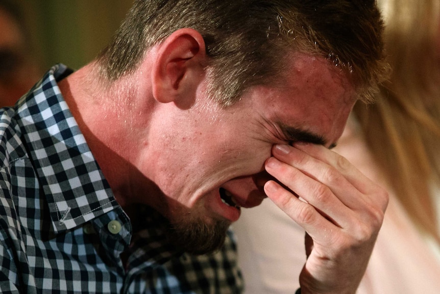 Samuel Zeif holds his eyes while crying.