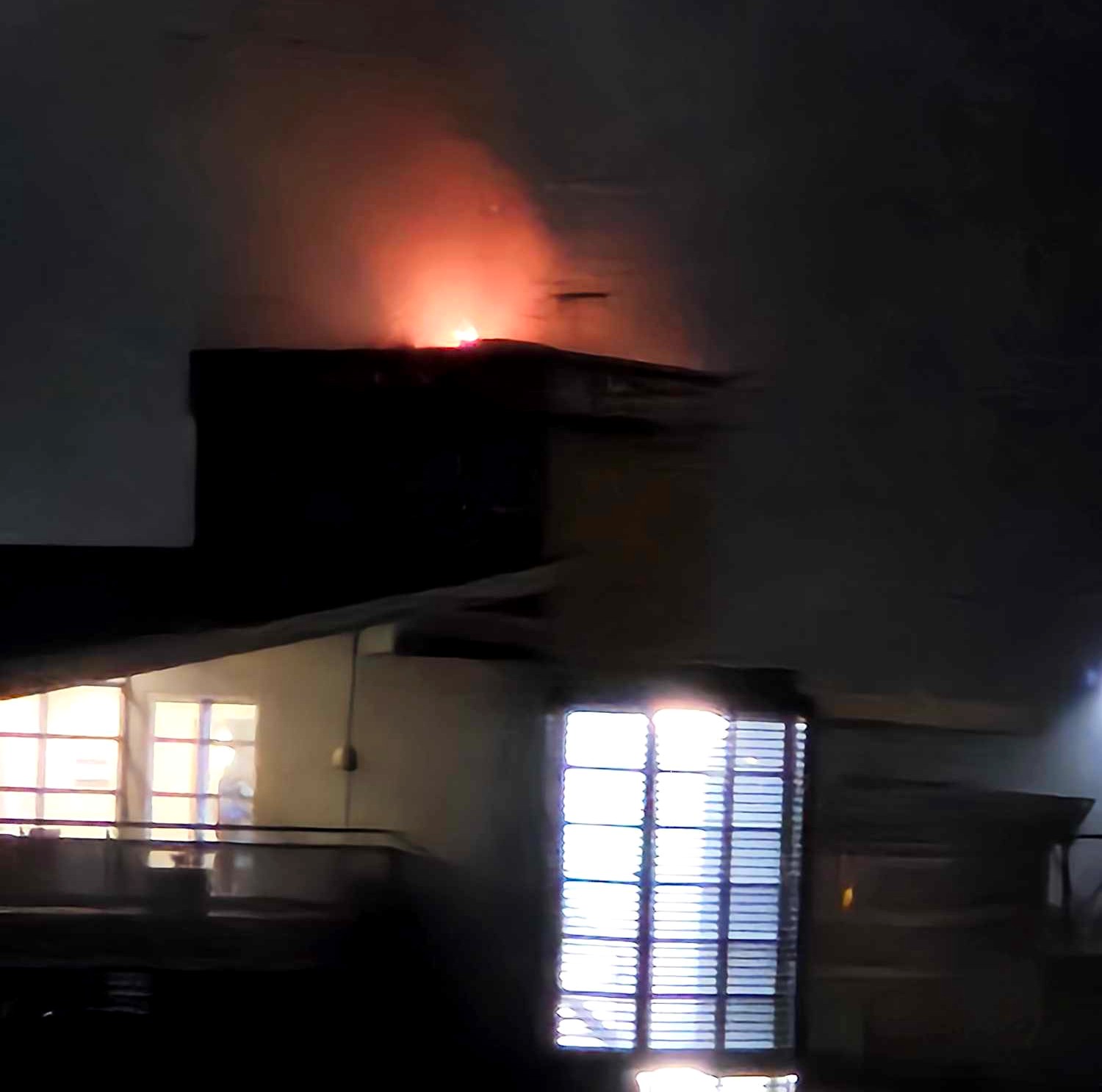 Fire on top of an apartment building at night