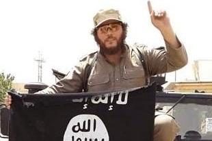 Australian jihadist Khaled Sharrouf, standing on the hood of a truck with an Islamic State flag.