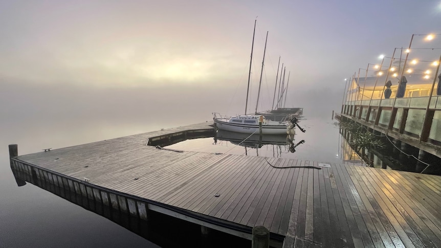 Yachts along a jetty on an overcast day