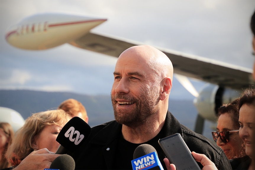 John Travolta talks to media in front of the Connie aircraft at the Shellharbour Airport.