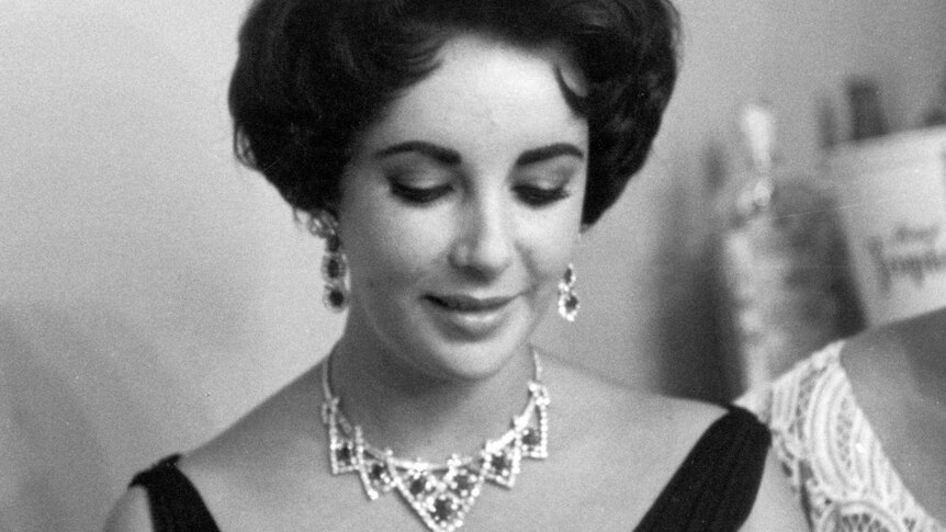 Elizabeth Taylor wearing a ruby and diamond necklace and earrings.