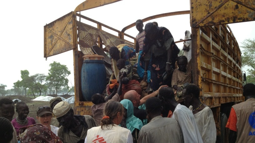 MSF screens refugees in the rain as they come off a truck from another refugee camp, nicknamed K18.