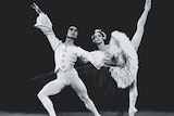 A male and a female ballet dancer strike a pose on stage