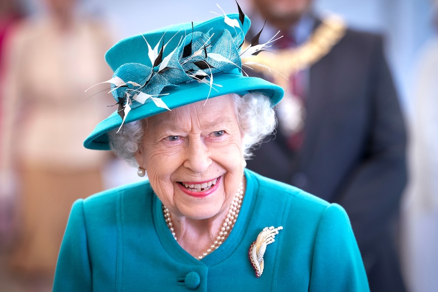 Queen Elizabeth smiles in a green dress and hat in this July archive photo.