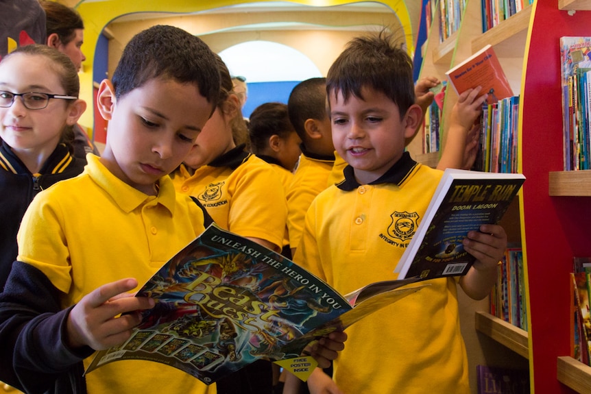 School students read in a library bus