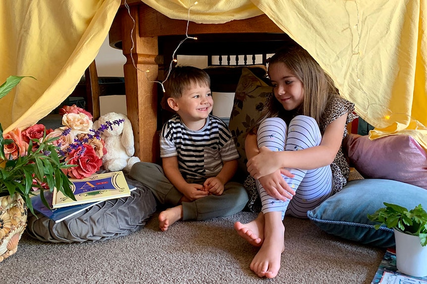A boy and a girl in their home made cubby
