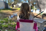 Back of little girl sitting on chair in a campground