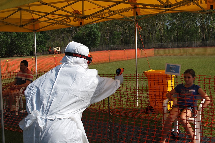 A health care worker takes a patient's temperature at an Ebola training session in Darwin