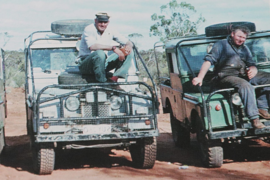 Three Landrovers withe three people sitting on the bonnets.