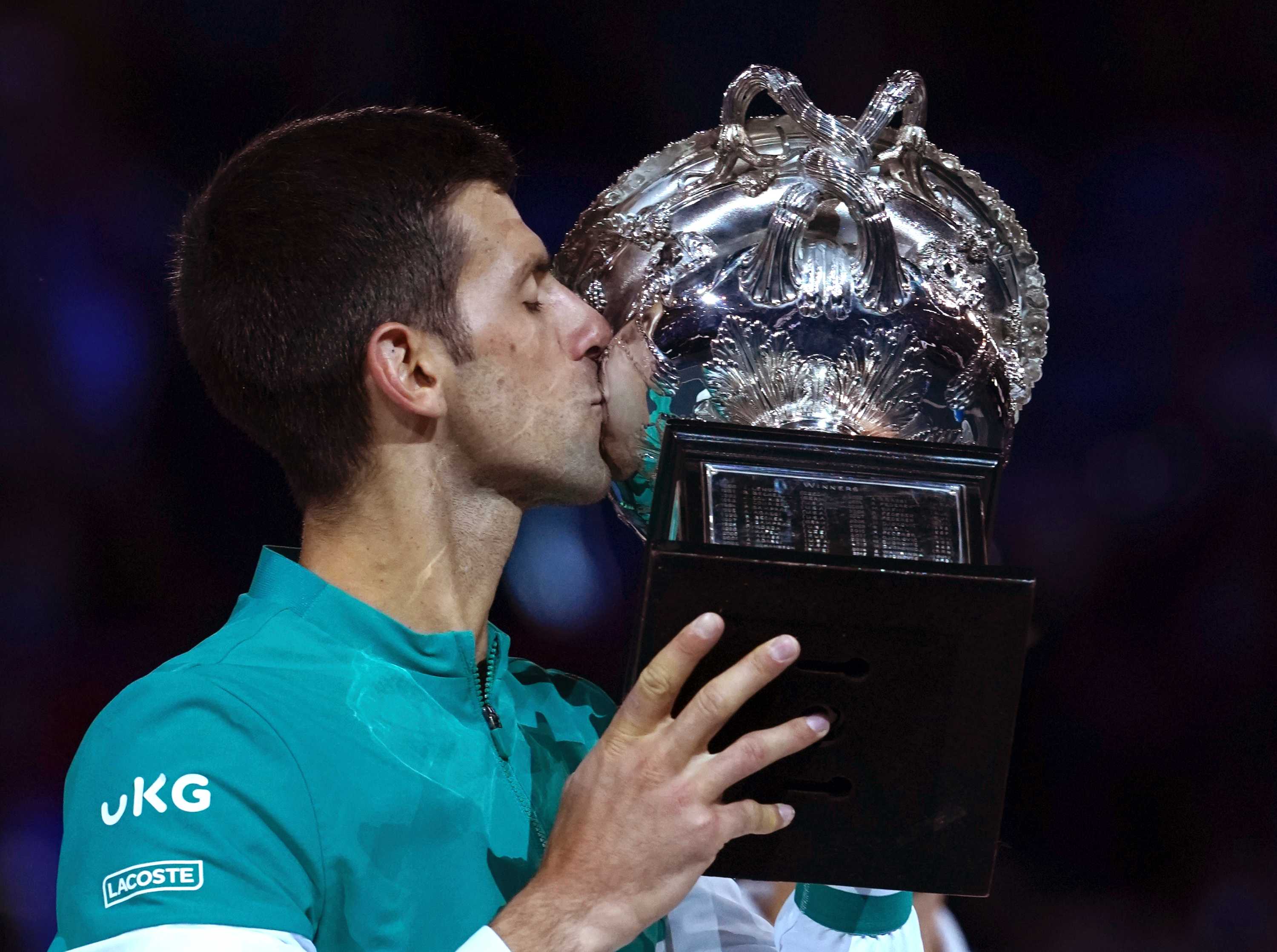 网球运动员用他的奖杯庆祝胜利。