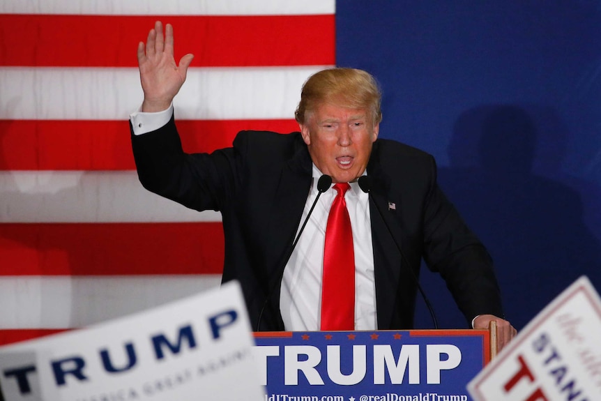 Donald Trump stands at a lectern addressing a crown in Iowa.