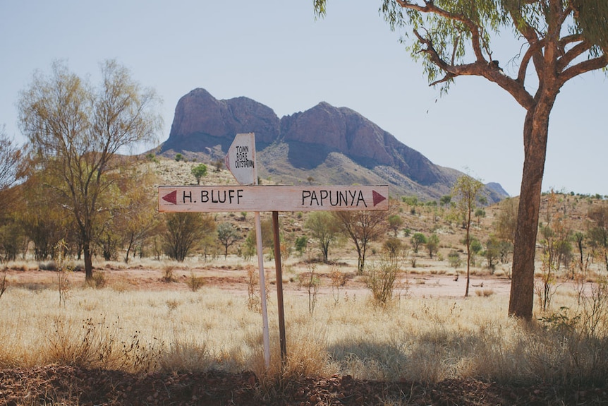 A road sign pointing to H Bluff on the left, Papunya on the right