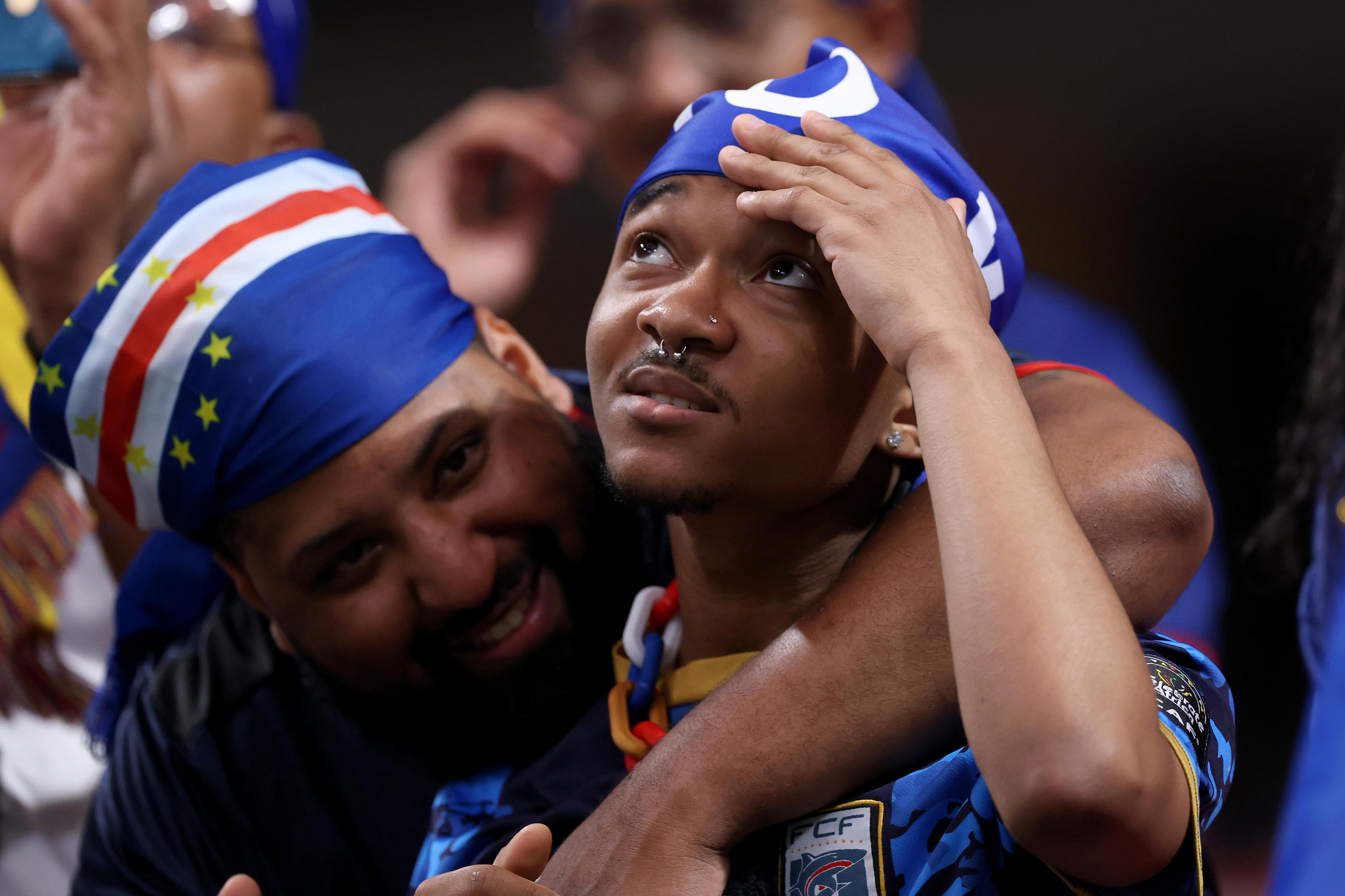 Two Cabo Verde fans embrace in the crowd