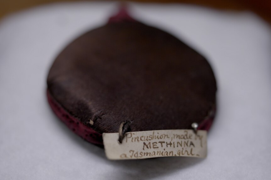 A closeup of the label of a pin cushion that says it was made by Methinna, a Tasmanian girl