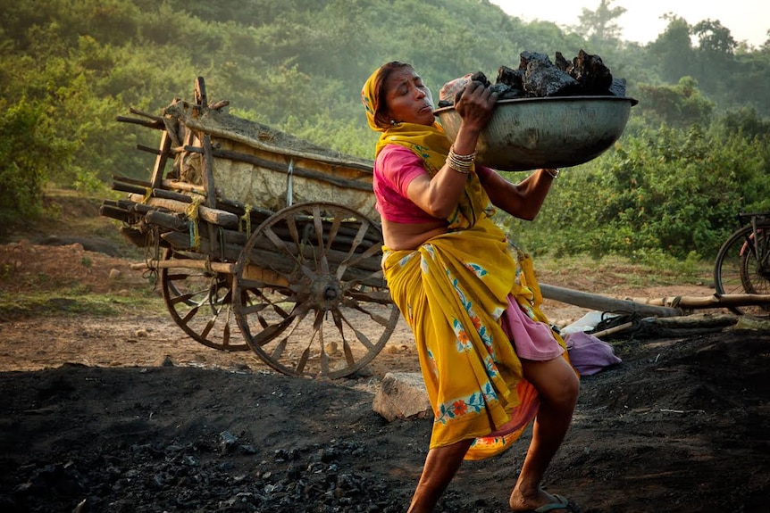 One of India's Indigenous Adivasis miners hauls coal.