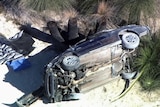 A car wreckage near bushland.