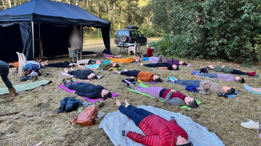 Meditation session on a grassy clearing in bushland.
