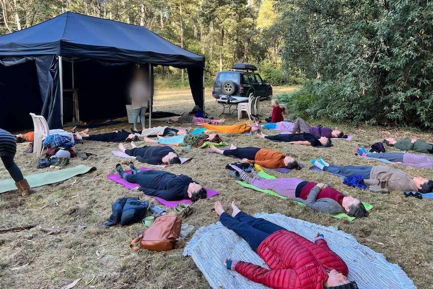 Meditation session on a grassy clearing in bushland.