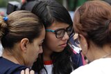 Two girls look devastated as a woman comforts them near the Enrique Rebsamen school in Mexico City.