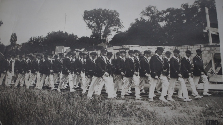 A historic black and white photo of the 1924 olympic team walking together. 